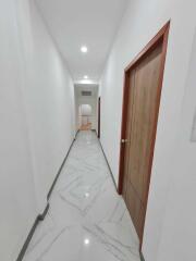 Hallway with wooden door and marble floor