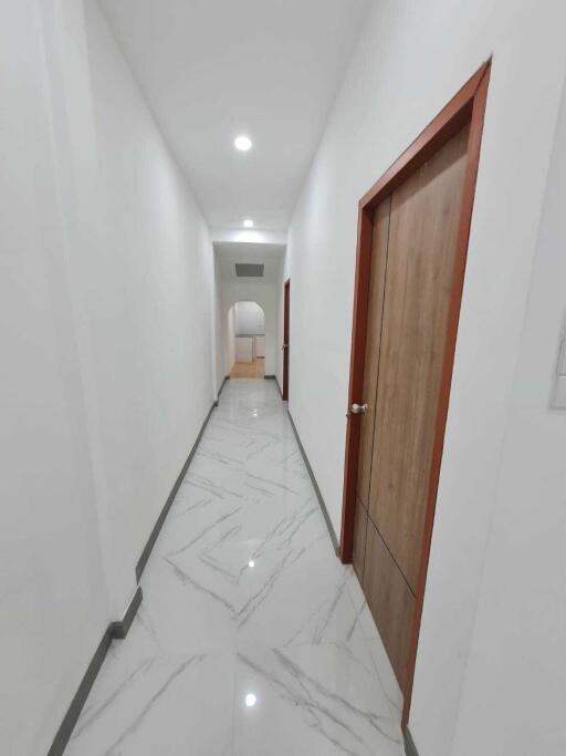 Hallway with wooden door and marble floor