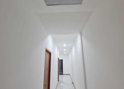 Long hallway with white walls and marble flooring