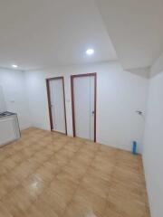 Spacious kitchen with tiled flooring and ceiling lights