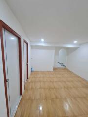 Spacious hallway with tiled flooring and recessed lighting