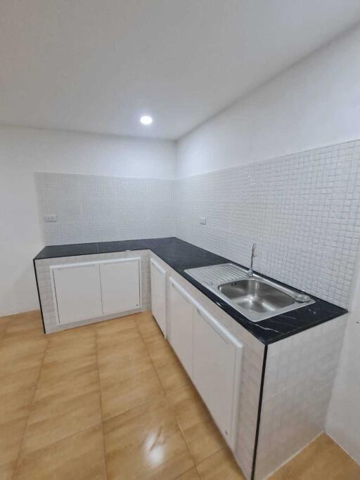 Modern kitchen with white cabinets and black countertop