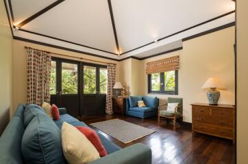 Beautiful living room with large windows, comfortable seating, and wooden flooring