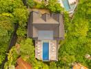 Aerial view of a building with pool surrounded by greenery