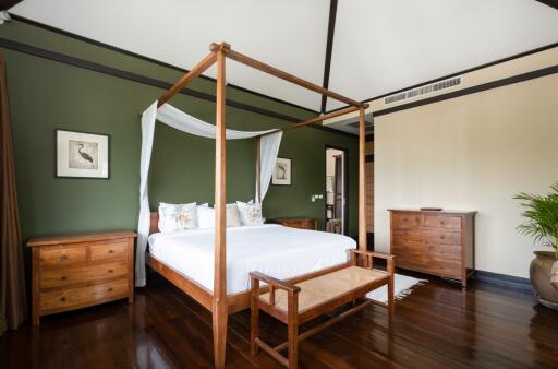 Spacious bedroom with wooden furniture and white bedding