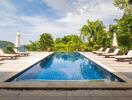 Luxurious outdoor swimming pool area with sun loungers and umbrellas