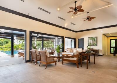 Modern living area with pool views and ceiling fans