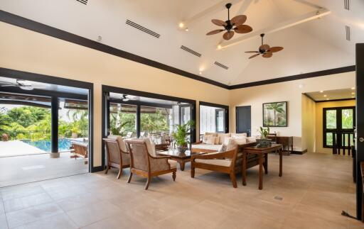 Modern living area with pool views and ceiling fans