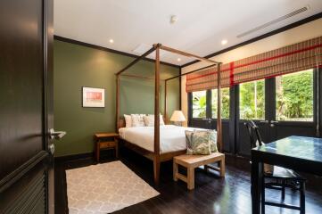 Spacious bedroom with canopy bed and garden view