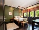 Spacious bedroom with canopy bed and garden view