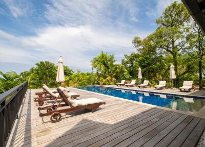 Luxurious outdoor pool area with lounge chairs and umbrellas