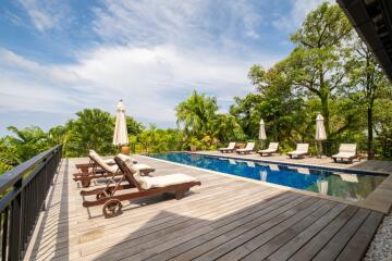 Luxurious outdoor pool area with lounge chairs and umbrellas