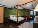 Bedroom with green walls, large bed, and wooden furniture