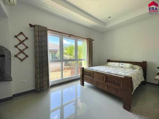 Bedroom with large window and wooden bed