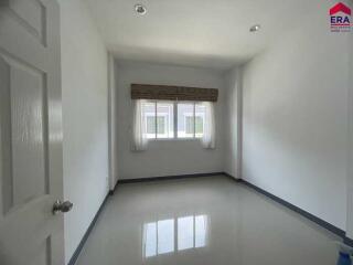 Empty room with a window and tiled flooring