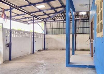 Covered outdoor area with blue painted walls and metal roofing