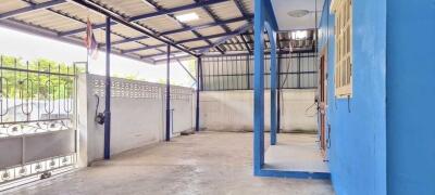 Covered outdoor area with blue painted walls and metal roofing