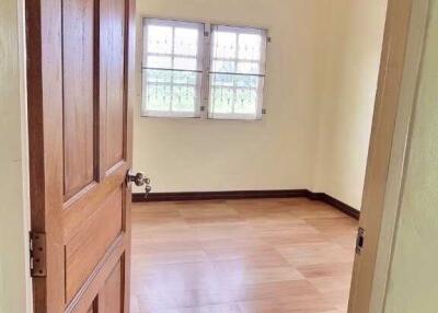 Spacious bedroom with wooden door and natural lighting