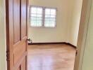 Spacious bedroom with wooden door and natural lighting