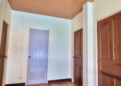 Hallway with three wooden doors and light-colored walls