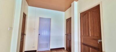 Hallway with three wooden doors and light-colored walls