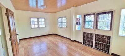 Spacious living room with wooden floor and large windows