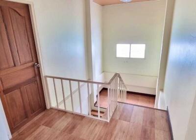 Interior view of a staircase with wooden flooring and a window