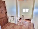 Interior view of a staircase with wooden flooring and a window