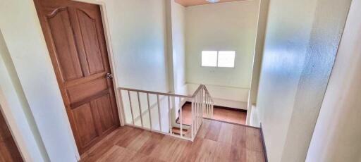 Interior view of a staircase with wooden flooring and a window