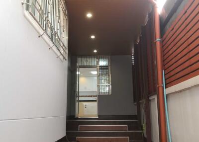 Well-lit hallway with ceiling lights and window grills