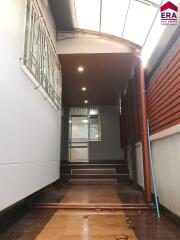 Well-lit hallway with ceiling lights and window grills