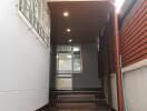 Well-lit hallway with ceiling lights and window grills