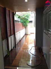 Covered patio area with wooden ceiling and tiled floor