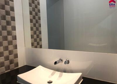Modern bathroom with checkered wall tiles, sink, and mirror