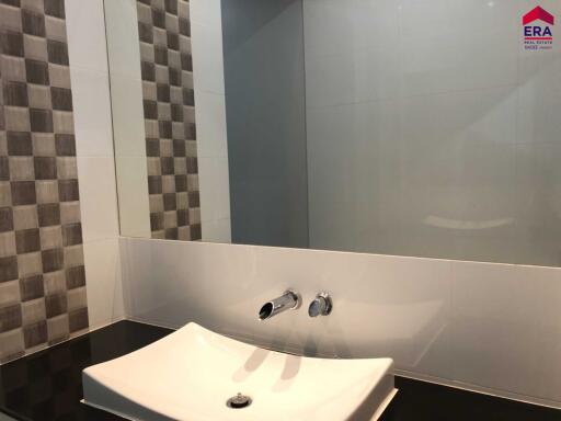 Modern bathroom with checkered wall tiles, sink, and mirror