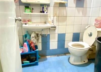 Bathroom with white and blue tiles, toilet, and sink