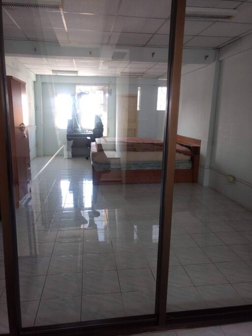 Spacious bedroom with glass doors and a desk by the window