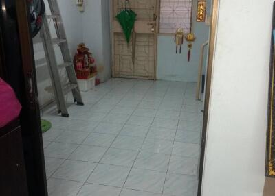 entryway with tiled floor, ladder, and decorated door