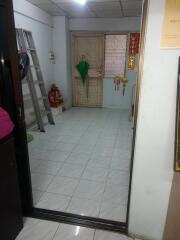 entryway with tiled floor, ladder, and decorated door