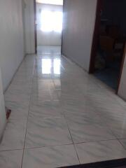 Hallway with tiled floor leading to a room with a window