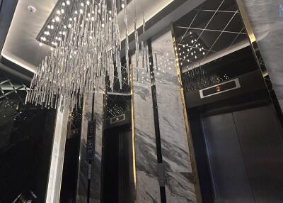 Elegant building lobby with modern elevator and chandelier