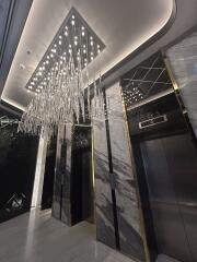 Elegant building lobby with modern elevator and chandelier