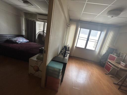 Bedroom and adjacent room with wooden flooring, window, and fan