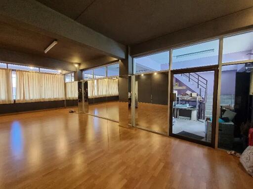 Spacious room with wooden flooring and large mirrors