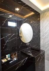 Modern bathroom with marble finishes and a round mirror