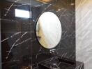 Modern bathroom with marble finishes and a round mirror