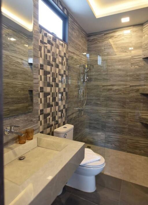 Modern bathroom with tiled walls and glass-enclosed shower