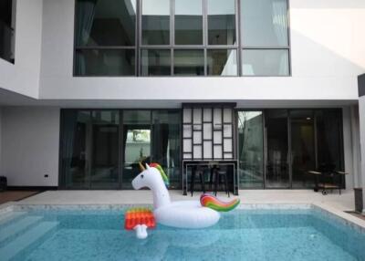 Outdoor view of a building with pool and inflatable unicorn float