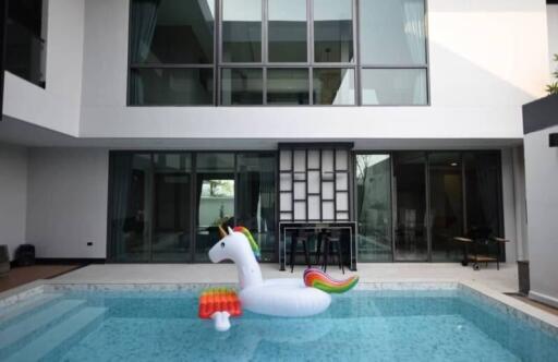 Outdoor view of a building with pool and inflatable unicorn float