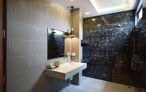 Modern bathroom with textured tiles and large mirror